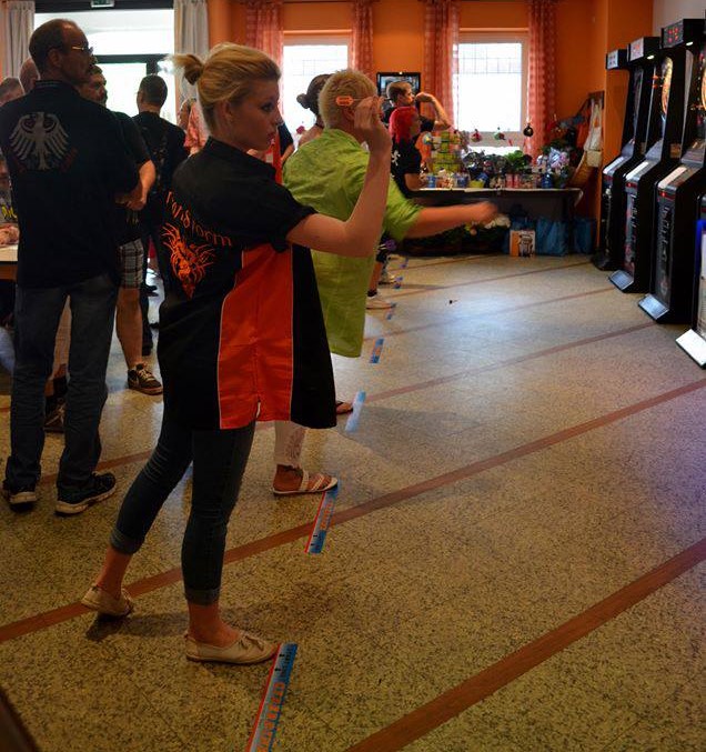 Eine Reihe von Dartautomaten mit Spielern.